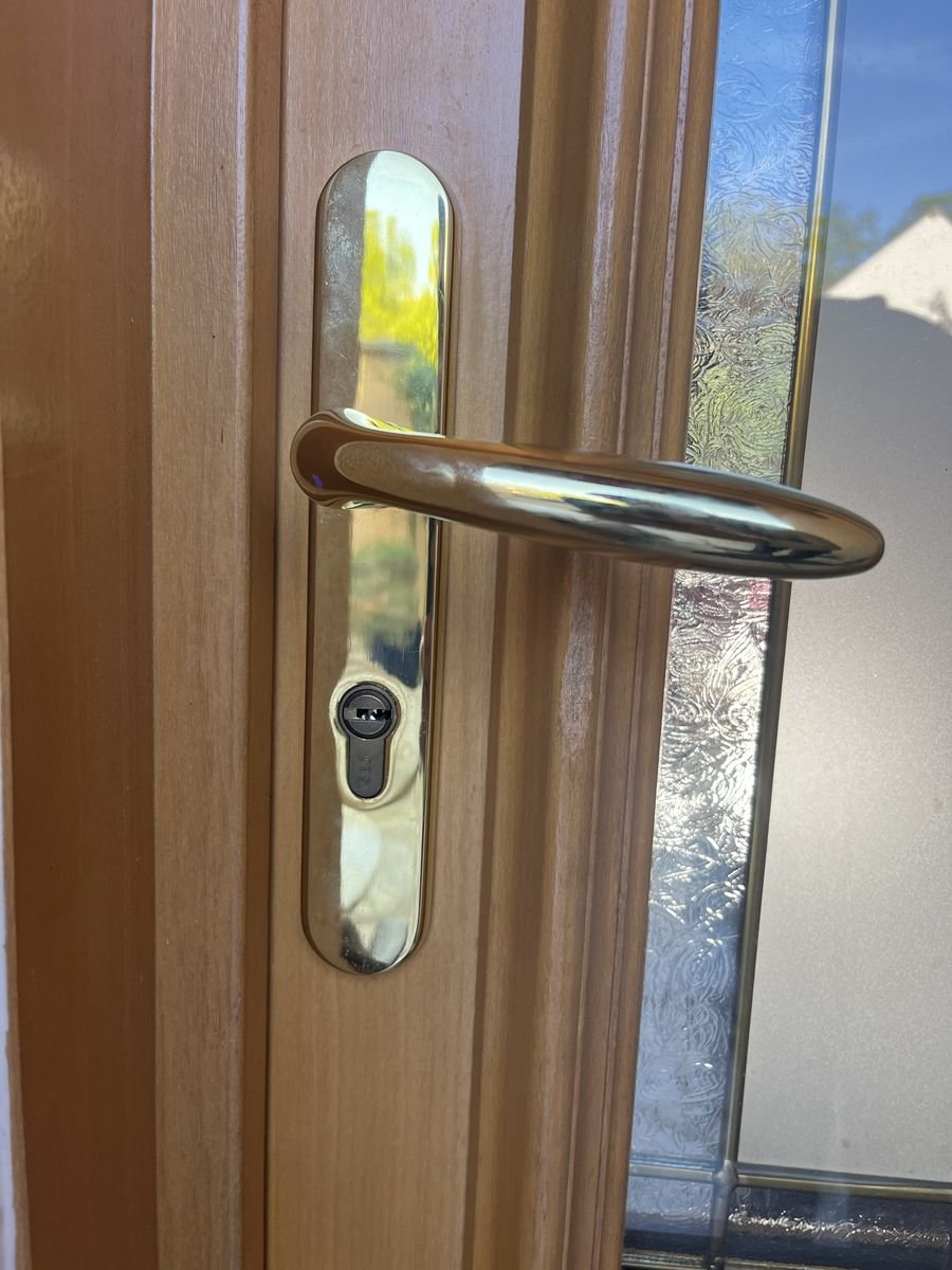 Plaque laiton et cylindre ISEO posés sur une porte d'entrée en bois – serrurier à Mours