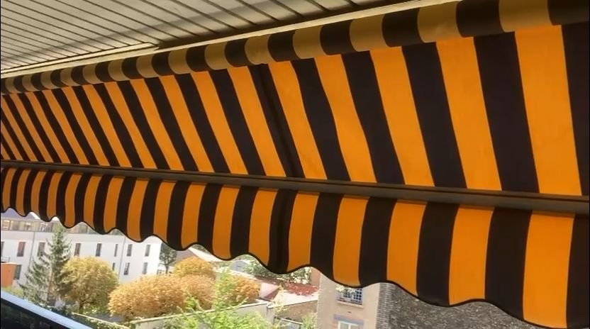 New striped fabric and scalloped valance fitted on a balcony awning – awning in Berville