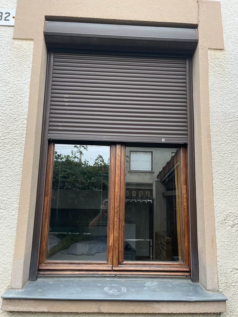 Brown external-box roller shutter fitted over an exotic-wood window – roller shutter repair in Les Granges-le-Roi